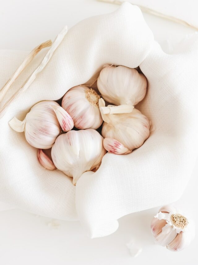 five garlic on white textile