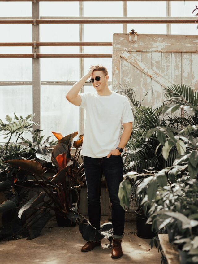 man standing surrounded by potted flowers